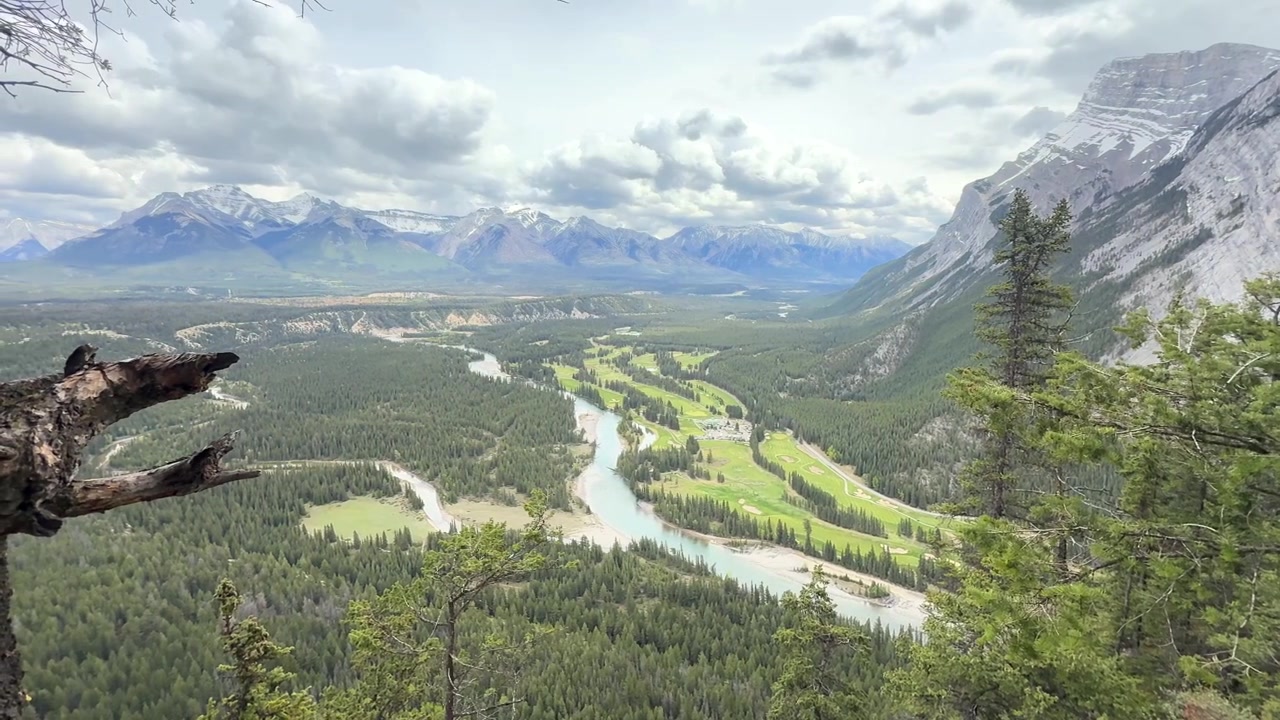 Vista a mano da Tunnel Mountain sulla valle del fiume Bow nel Parco Nazionale di Banff, con il campo da golf Fairmont che si estende sotto in una luce diurna uniforme
