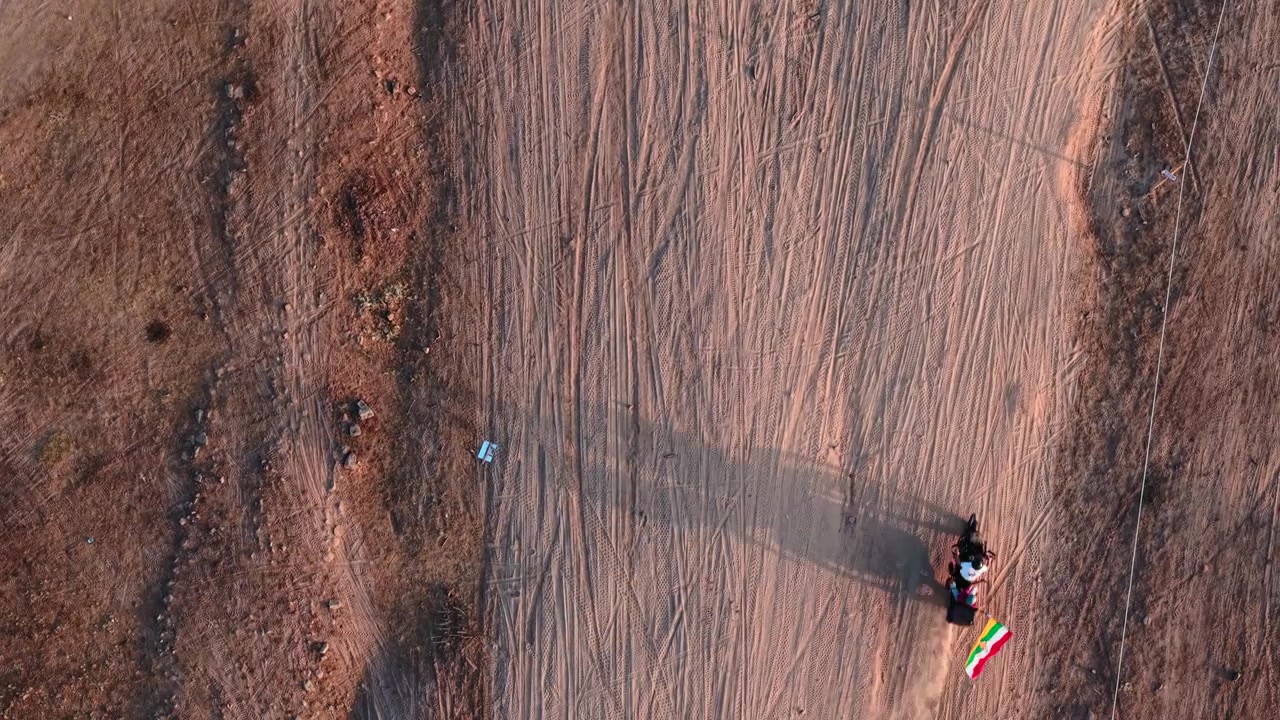Vista aerea di motociclisti che guidano su una pista sterrata al tramonto