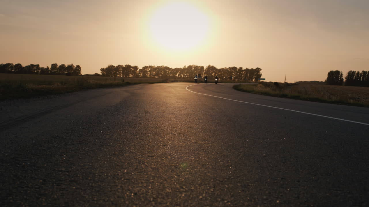 tres ciclistas conducen por la carretera pasando la cámara 1