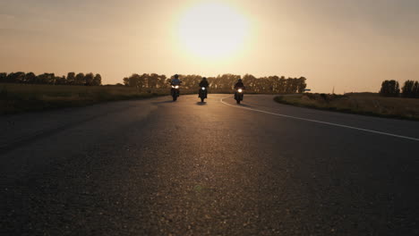 Three-bikers-drive-along-the-highway-past-the-camera-1