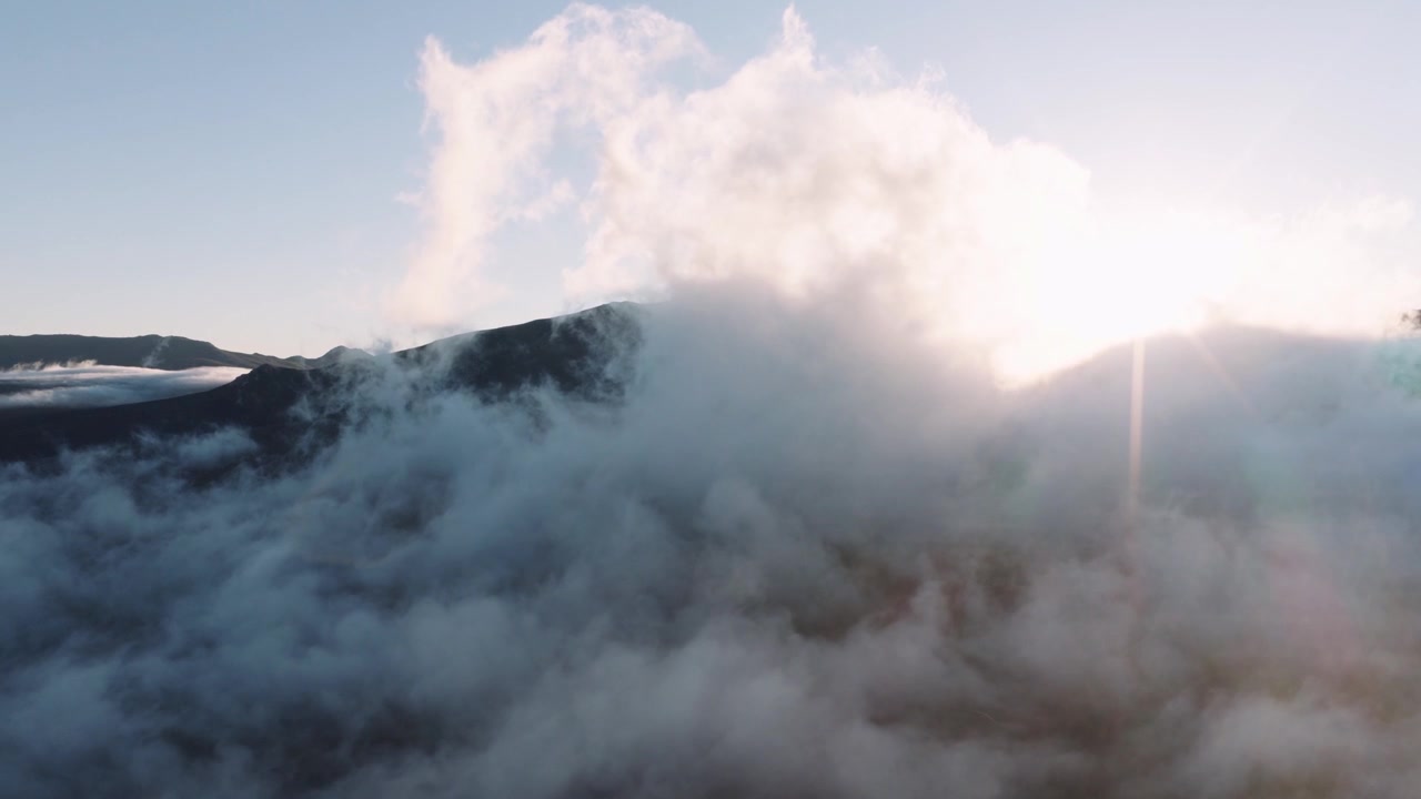 Aerial Lift Off Through Clouds to Reveal Mountain and Sunrise