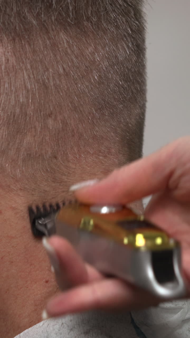 Nærbillede af hårtrimmer, der klipper hår i nakken
