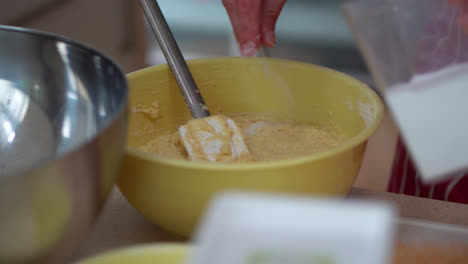 hands mixing potato dough and flour in a bowl. making bryndza dumplings in the kitchen. close up