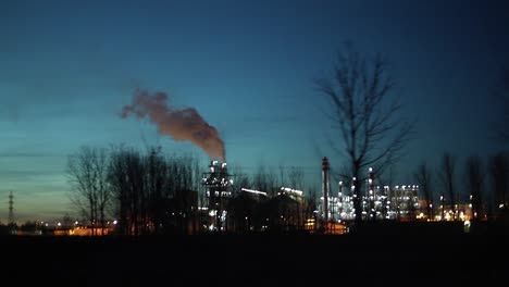 Zona-Industrial-Con-Una-Tubería-Grande-Se-Vierte-Humo-Blanco-Grueso-De-La-Tubería-De-Fábrica-Por-La-Noche