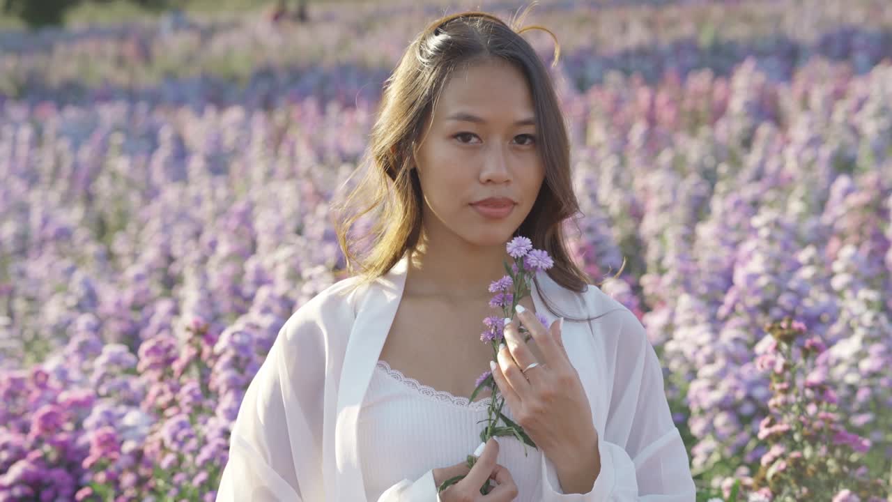 꽃에서 즐겁게 놀고 있는 행복한 태국 여자