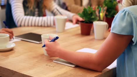 mujer de negocios casual tomando notas durante una reunión