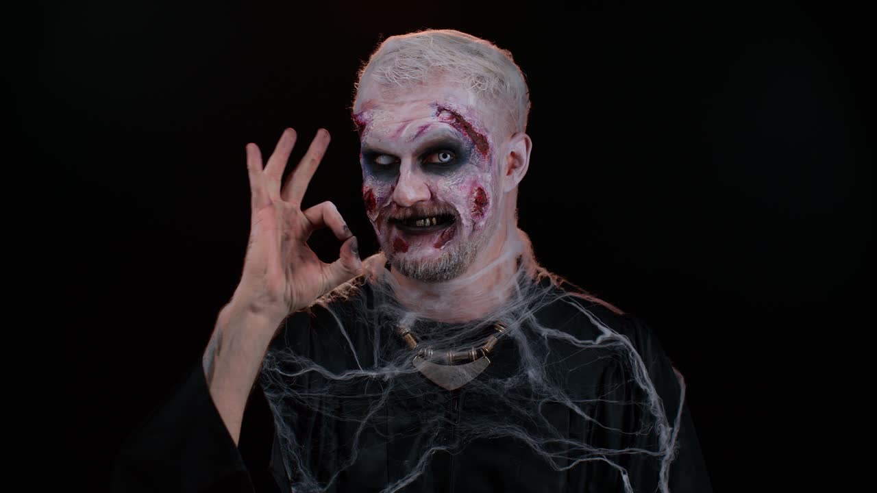 hombre espeluznante halloween zombie mostrando ok gesto, como signo positivo algo bueno, sonríe terriblemente