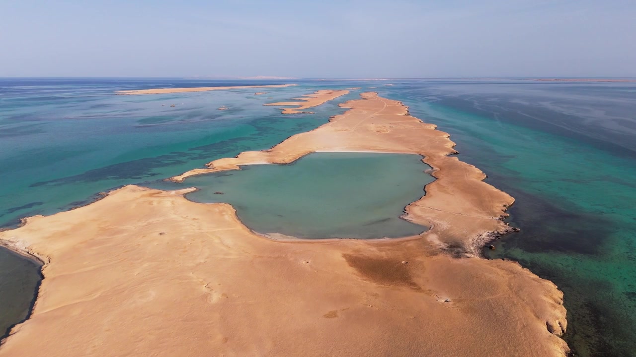 Droneoptagelser af Juzur Ashrafi-øen, Egypten, der viser levende turkise farvande og barske klipper på et isoleret og fjerntliggende sted i Det Røde Hav