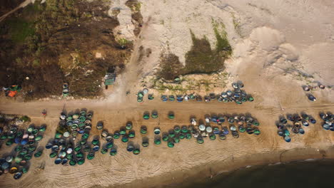 aerial birdseye dolly right of bunch of coracle boats on seashore in la gi, vietnam