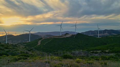 parque eólico con turbinas eólicas giratorias que proporcionan una fuente de energía respetuosa con el medio ambiente para la protección del clima y la producción sostenible de energía en málaga, españa, durante la puesta de sol
