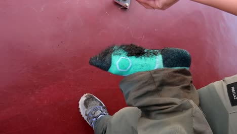 cerca de mujer quitándose botas de trekking zapatos llenos de tierra y arena mojada