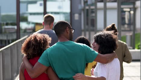 Friends-embracing-and-walking-outdoor