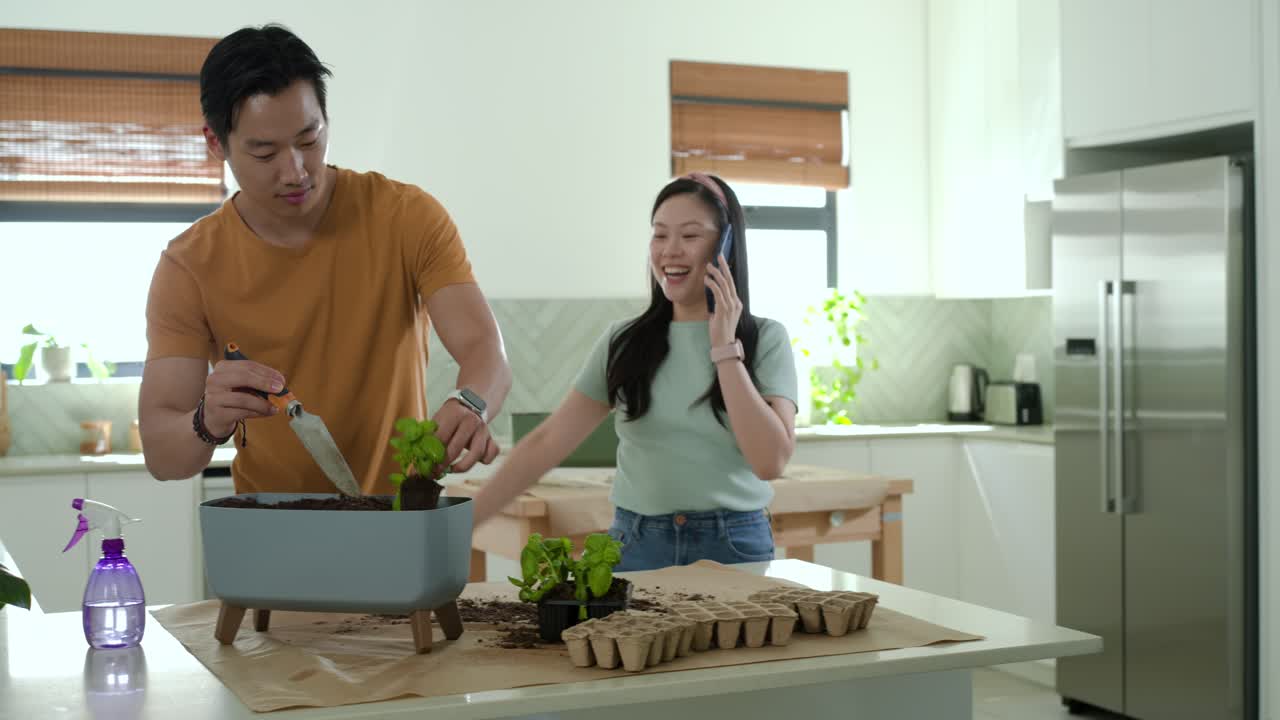 キッチンアイランドで夫婦が苗を植えている。その間に女性が電話をしながら戻ってきて、男性に腕を回し、再会を喜び合っている。