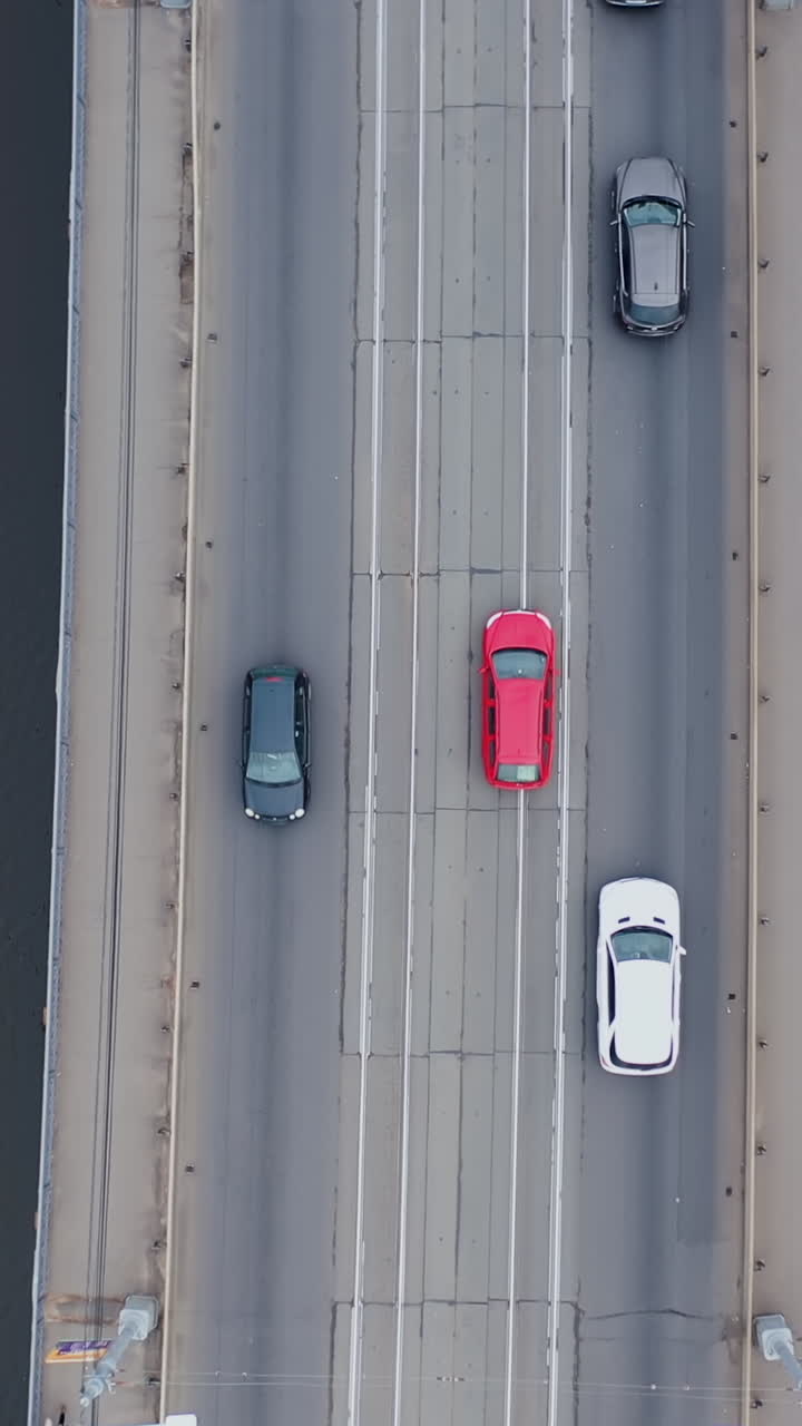 Dronerotation. Vejkryds og bro over flod i byen, luftfoto. Vertikal video