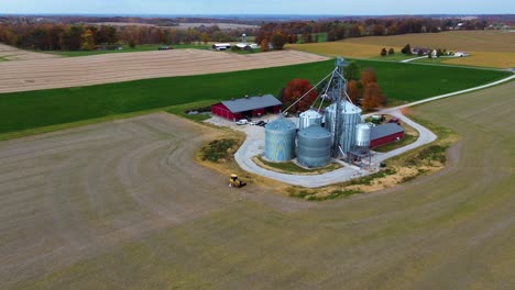 midwest farm with grain silos and barns, aerial drone
