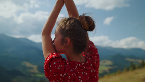 woman enjoying mountains beauty outdoors closeup. back view girl raising hands.