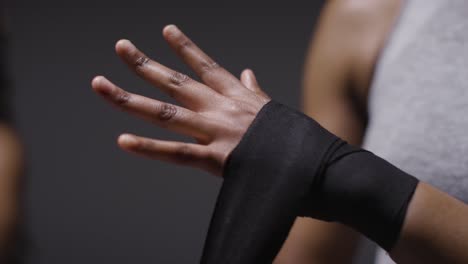 studio shot of women putting on boxing wraps on hands before exercising together 5