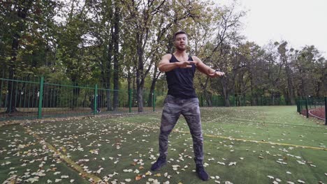 Man doing stretching exercise. Fitness man preparing for workout in the park