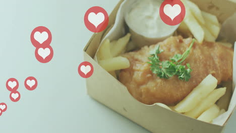 heart icons animation over fish and chips in takeaway box