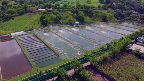 sun reflection of waters at aqua cultural fish farm in bonao, dominican republic. aerial wide shot.