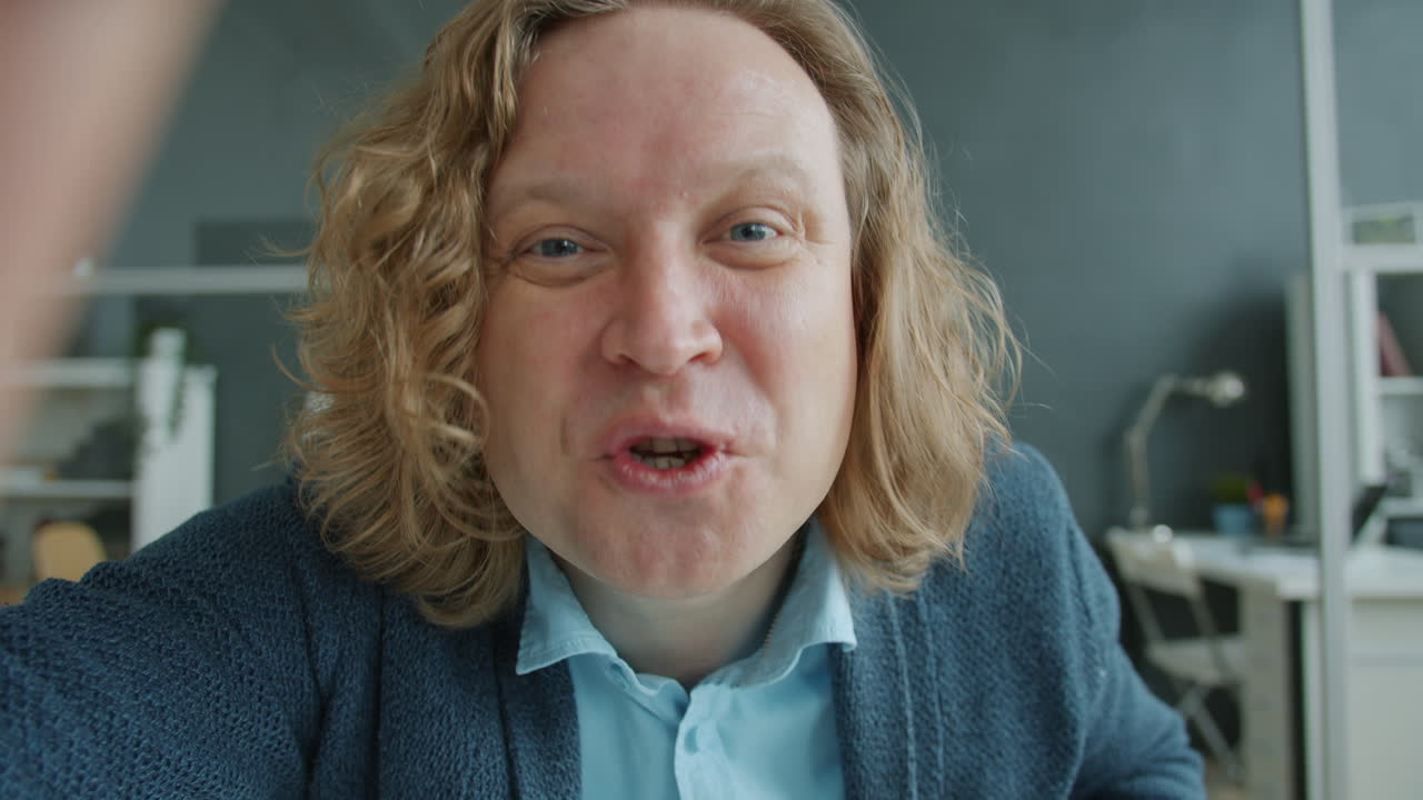 Smiling Man in Office Setting Taking Selfie