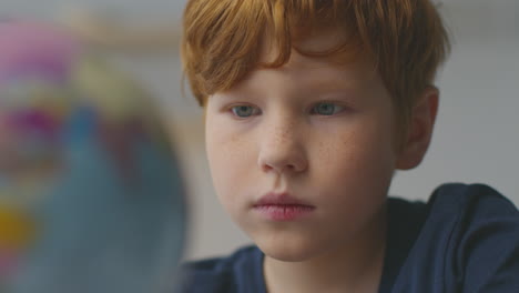 boy looking at a globe