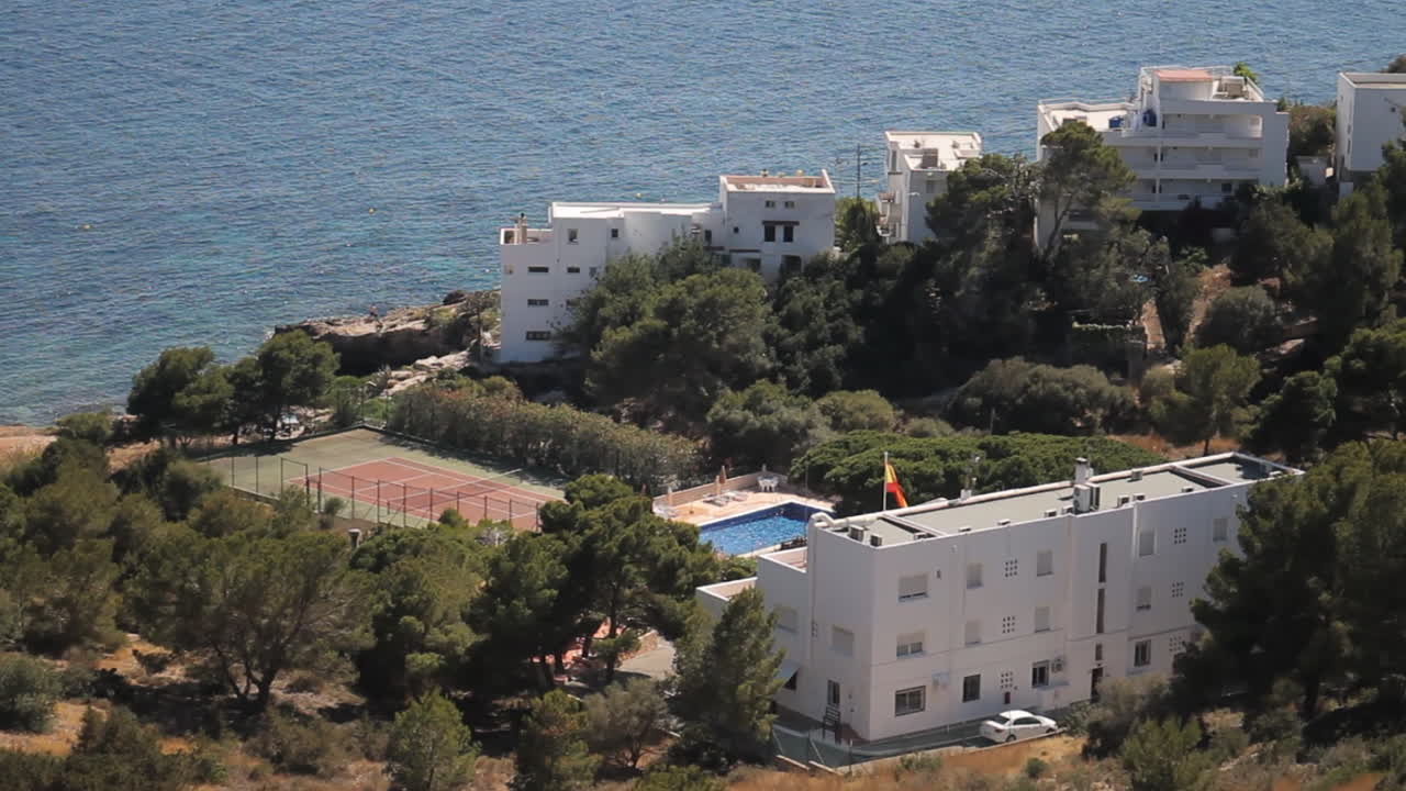 View of coastal buildings with tennis court and swimming pool