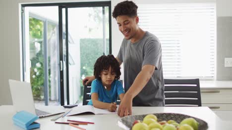 Glücklicher-Gemischtrassiger-Mann-Und-Sein-Sohn-Machen-Gemeinsam-Hausaufgaben