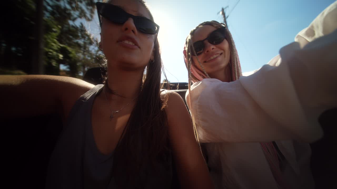 Friends enjoying a sunny road trip in a convertible