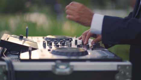 close-up of a man's hands playing music with a dj during the wedding reception party