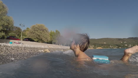 footage of two years old boy, playing with waves at santova beach, kalamata, greece