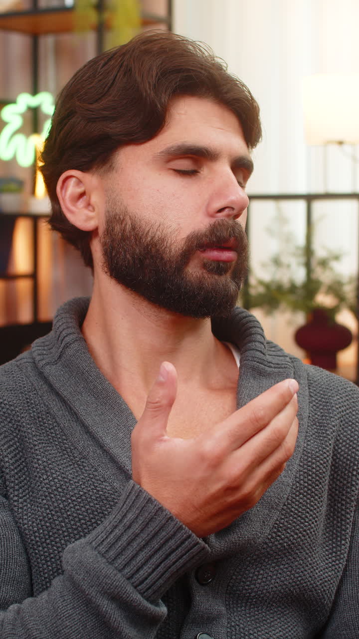 Indian man with closed eyes repeats quiet words palms together silent prayer calm breath mood softly