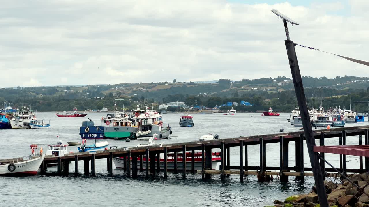 fotografía panorámica del puerto de dalcahue, barcos tradicionales amarrados en la orilla, isla de chiloé