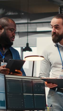 vertical video multiethnic work team consulting each other in completing monthly reports