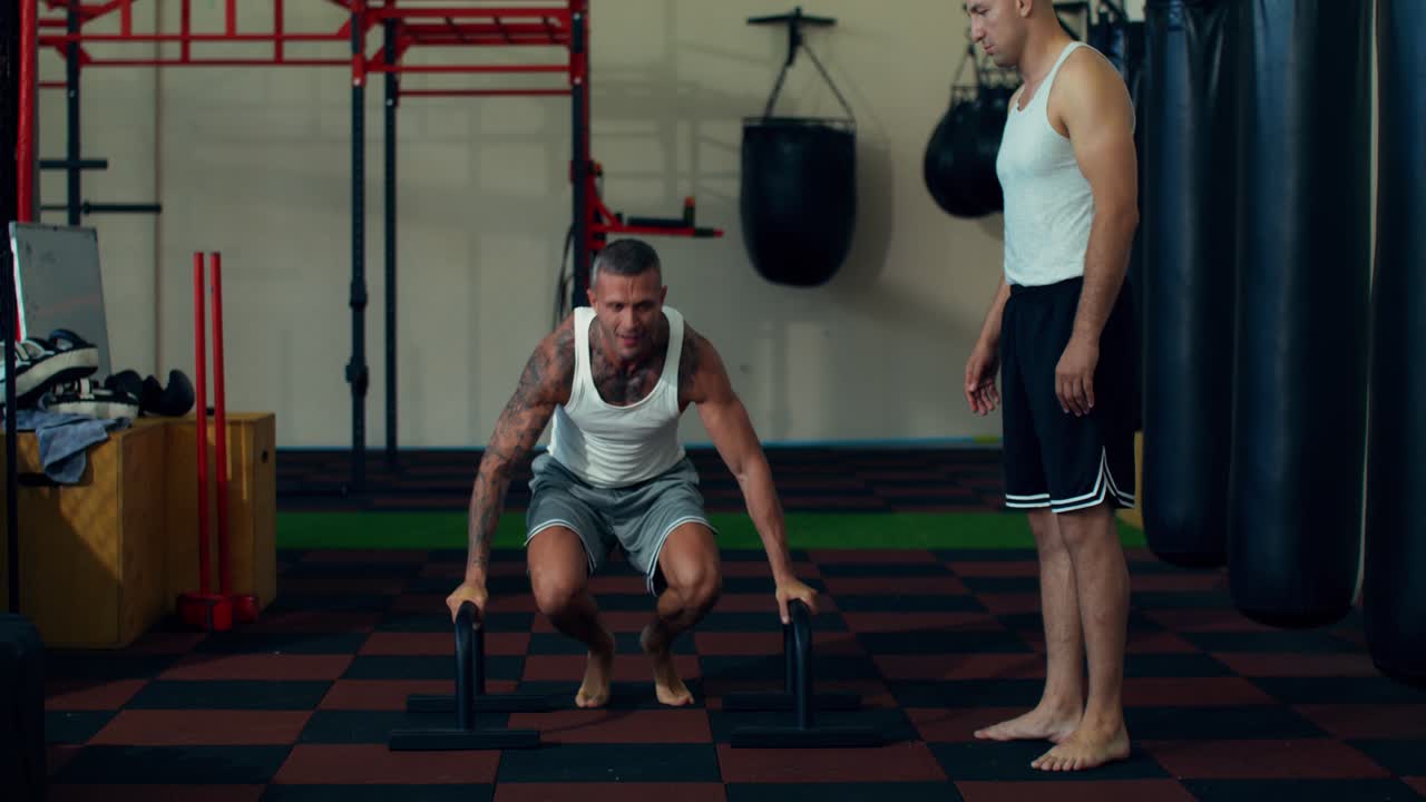 Men exercising in a gym with a trainer
