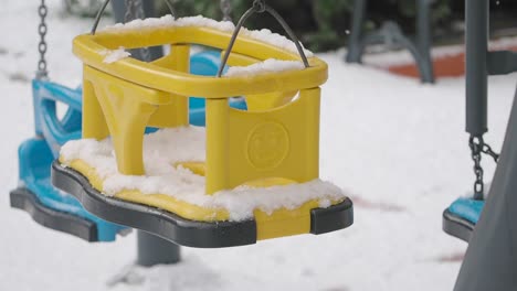 yellow child swing covered in snow