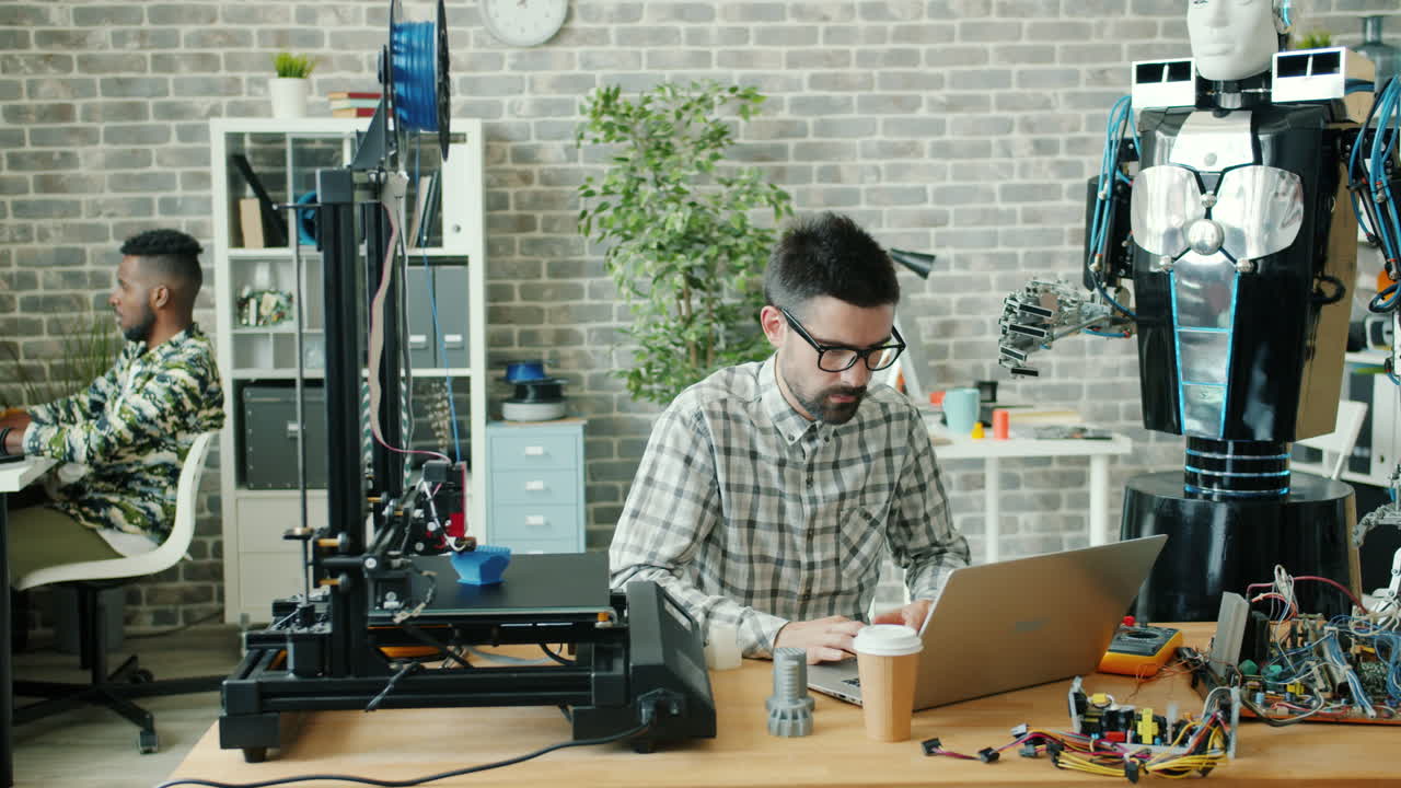 Engineer Working on 3D Printer and Robot in Modern Office