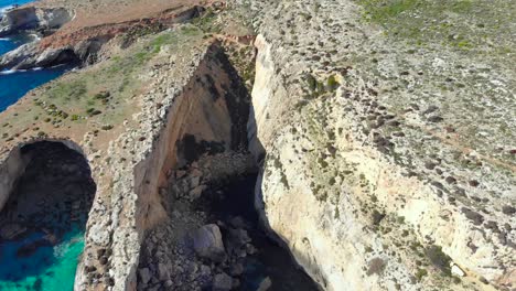 drone shot over rocks in nature over rocks - the mediterranean sea of malta