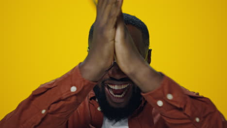 retrato de un feliz hombre africano celebrando la victoria sobre un fondo amarillo.