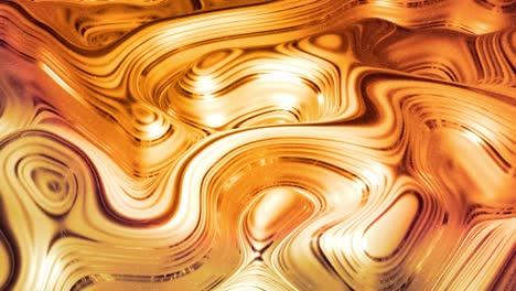looped abstract background with wavy sparkling golden liquid pattern on shiny glossy surface. viscous yellow fluid like surface of gold foil or brilliant glass. beautiful creative festive backdrop.