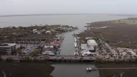 Aerial-descending-close-up-shot-of-Shem-Creek-on-a-hazy-day-in-Mount-Pleasant,-South-Carolina