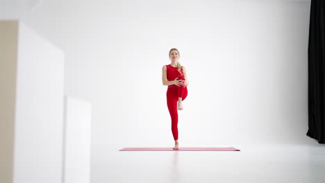 Schöne-Junge-Frau-In-Roter-Sportkleidung-Macht-Yoga--Oder-Pilates-Übungen-Auf-Weißem-Hintergrund.