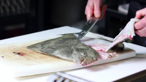 pescado de rodaballo crudo que se limpia y se corta en filetes en un establecimiento de vendedores de pescado