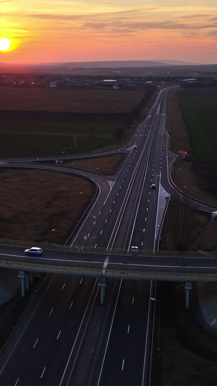 Aerial drone view of cars driving on the highway in Moldova at sunset. Vertical
