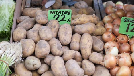 a pile of potatoes and onions at a market