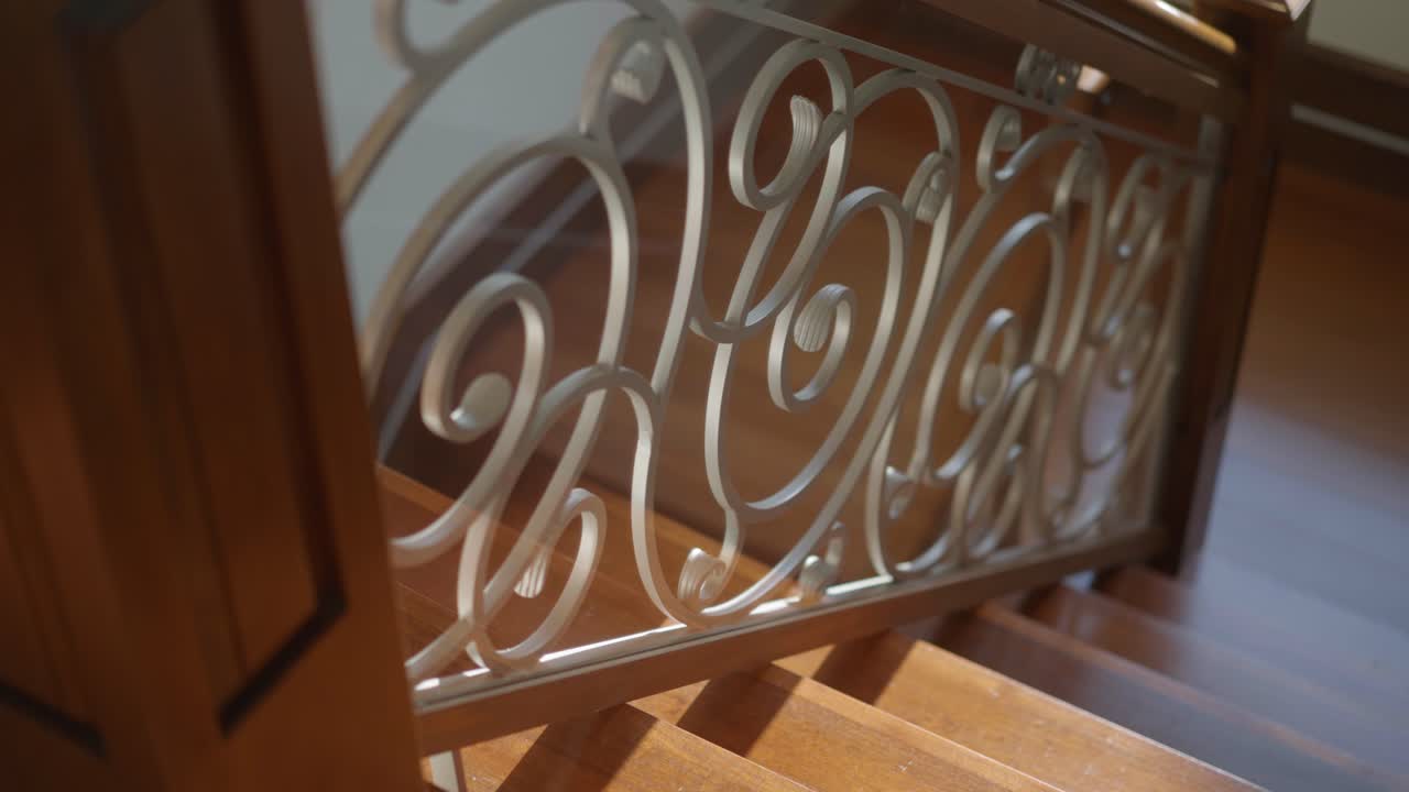 A cinematic shot of an elegant staircase in a luxury home with the sun shining creating beautiful shadows and silhouettes