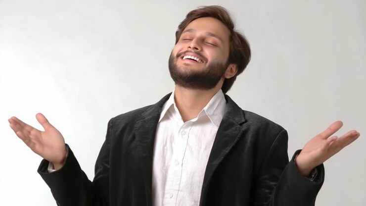 Gioiosa espressione di beato appagamento: un uomo in abito formale sorride felice con le braccia tese, irradiando positività e felicità su uno sfondo neutro
