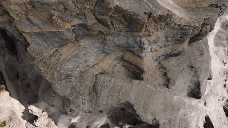 Aerial-top-down-of-rocky-mountain-with-steep-cliffs-and-edge-in-sunlight