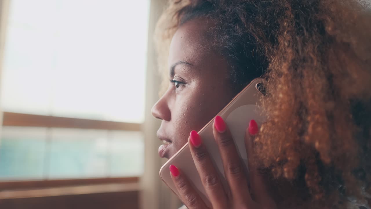 Close de uma mulher afro-americana tendo uma conversa entediante e revirando os olhos