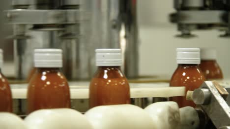 syrup bottle in assembly line moving full from